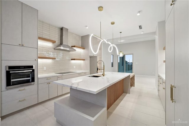 kitchen with black electric stovetop, backsplash, a sink, wall chimney range hood, and oven