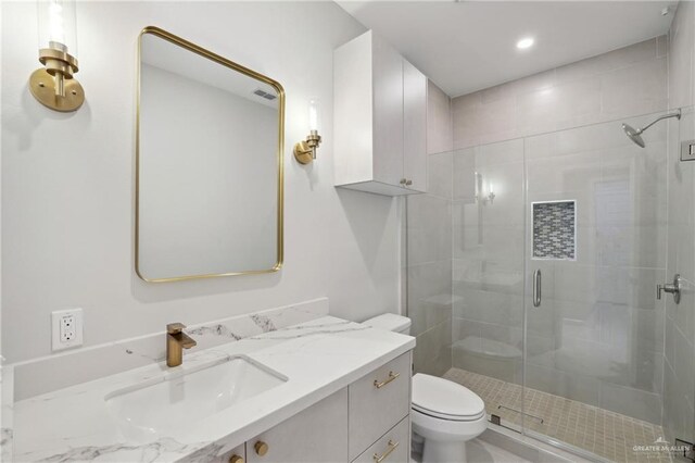 full bathroom with toilet, a stall shower, and vanity