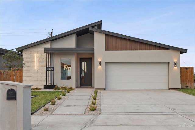 view of front of home with a garage, fence, concrete driveway, and stucco siding