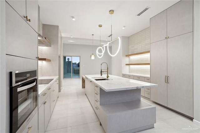 kitchen with visible vents, under cabinet range hood, stainless steel oven, open shelves, and a sink