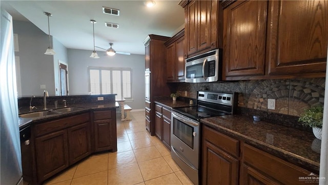4919 Crown Point St, Edinburg, TX 78541 - kitchen featuring stainless steel appliances, tasteful backsplash, light tile patterned floors, a sink, and decorative light fixtures
