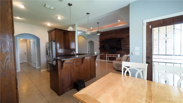 4919 Crown Point St, Edinburg, TX 78541 - kitchen with arched walkways, a kitchen breakfast bar, open floor plan, ceiling fan, and stainless steel fridge