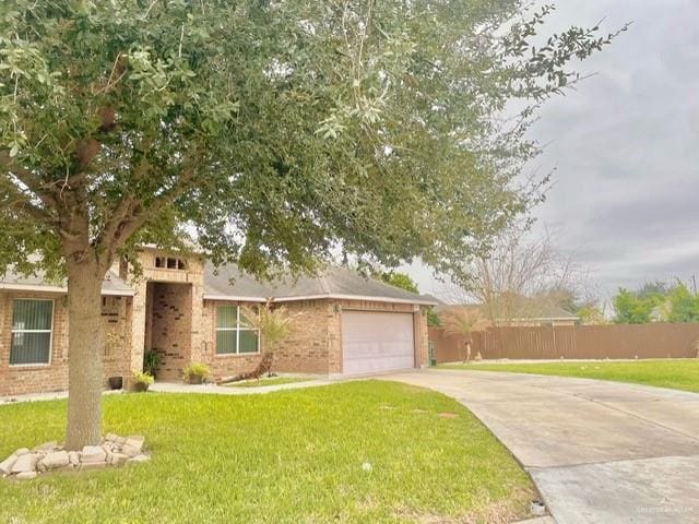 view of front of property with a garage, driveway, a front yard, and fence