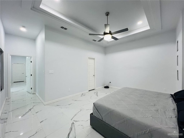 bedroom featuring a raised ceiling and ceiling fan