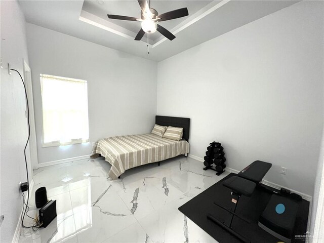 bedroom featuring a raised ceiling and ceiling fan