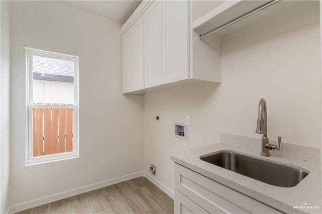 washroom with hookup for an electric dryer, washer hookup, cabinets, sink, and light hardwood / wood-style flooring