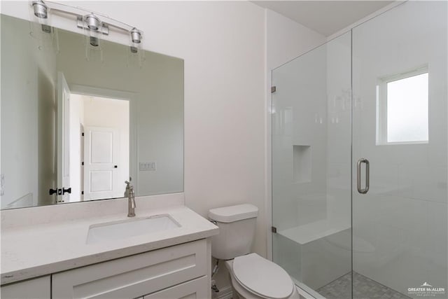 bathroom with toilet, vanity, and walk in shower