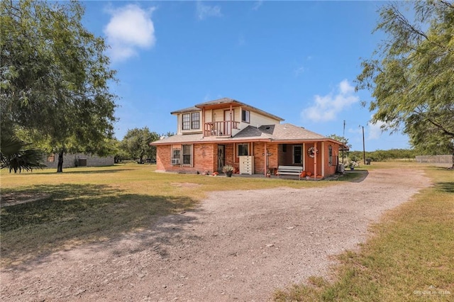 7027 Jo Din St, Edinburg, TX 78542 - view of front facade with dirt driveway, a balcony, a front lawn, and covered porch