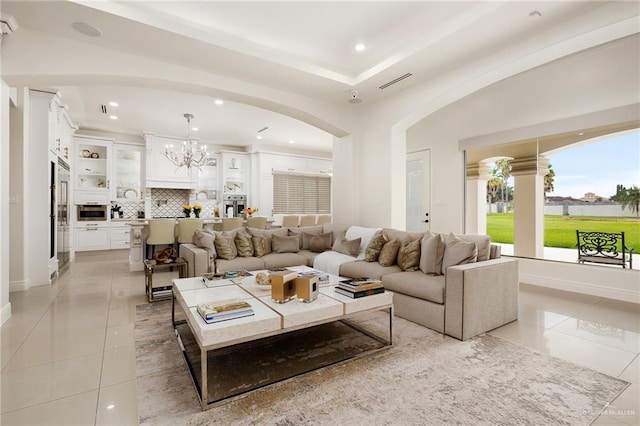 tiled living room featuring a notable chandelier