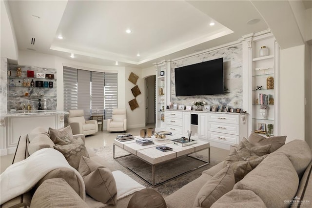 living room featuring built in shelves and a tray ceiling