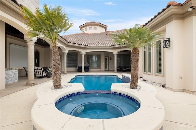 view of pool with a patio area and an in ground hot tub