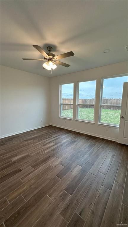 spare room with a wealth of natural light, dark hardwood / wood-style floors, and ceiling fan