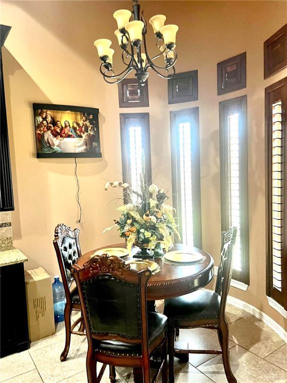 dining space featuring a notable chandelier, light tile patterned floors, and a wealth of natural light