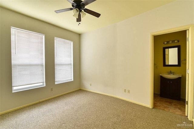 carpeted empty room featuring ceiling fan and sink