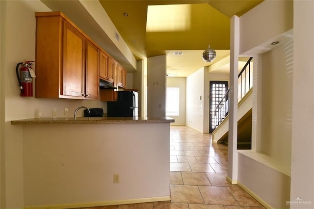 kitchen featuring ceiling fan, sink, black fridge, kitchen peninsula, and light tile patterned floors