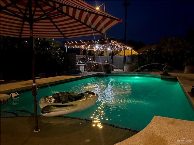 pool at night with pool water feature