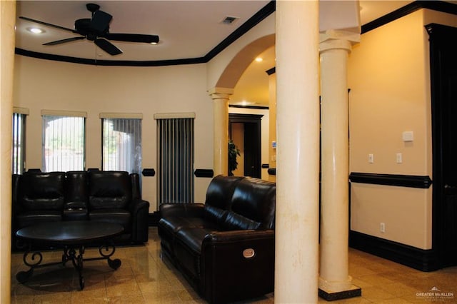 living room with decorative columns, crown molding, and ceiling fan