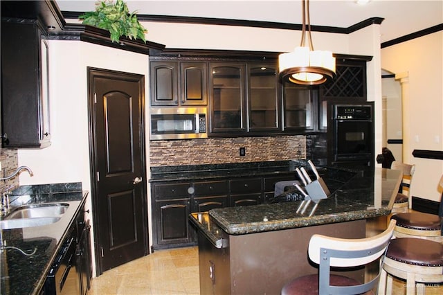 kitchen featuring tasteful backsplash, dark brown cabinets, sink, oven, and hanging light fixtures