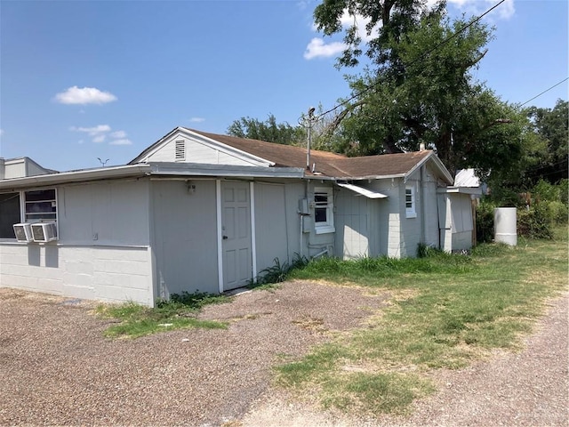 view of property exterior with a yard and cooling unit