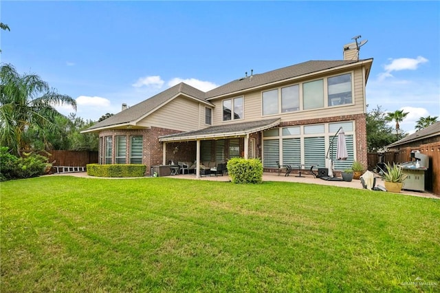 back of property with a yard and a patio