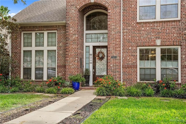 entrance to property with a lawn