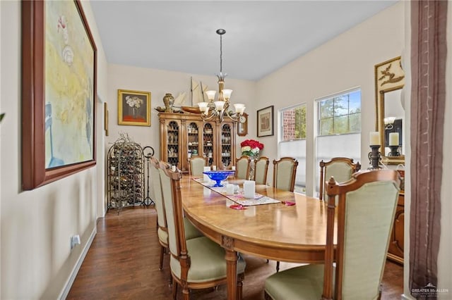 dining area featuring dark hardwood / wood-style floors and an inviting chandelier