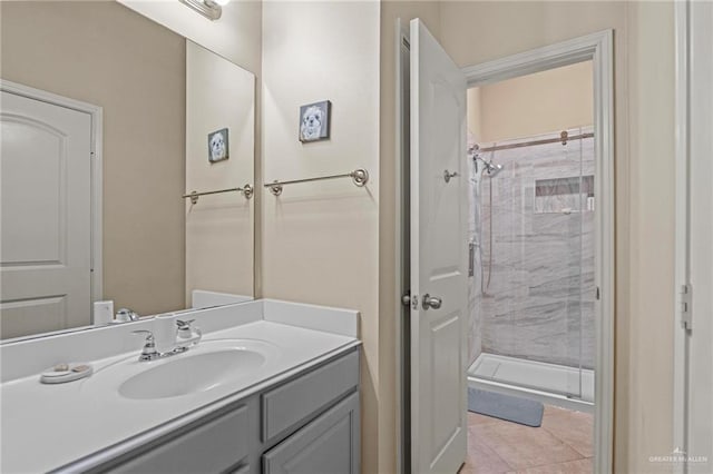 bathroom featuring tile patterned flooring, vanity, and a tile shower