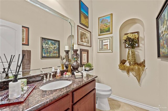 bathroom with tile patterned flooring, vanity, and toilet