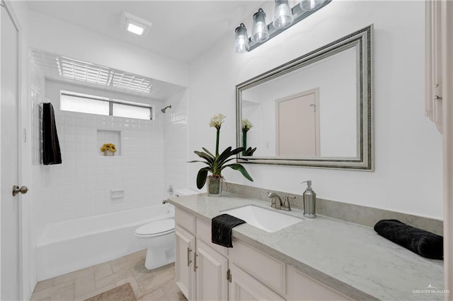 bathroom featuring washtub / shower combination, stone finish floor, vanity, and toilet