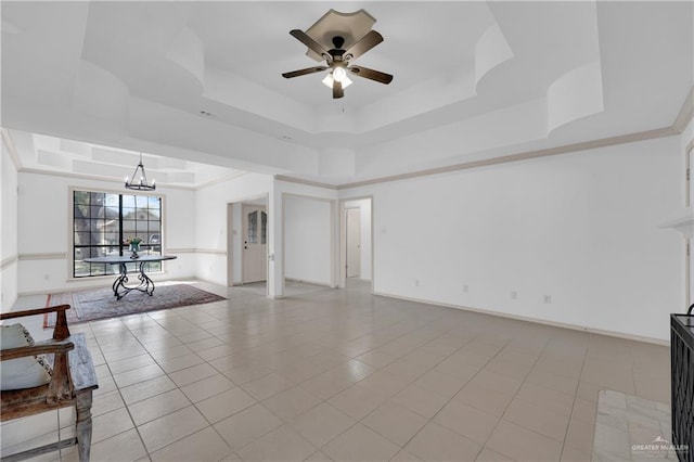 unfurnished living room featuring a tray ceiling, a fireplace, light tile patterned flooring, baseboards, and ceiling fan with notable chandelier