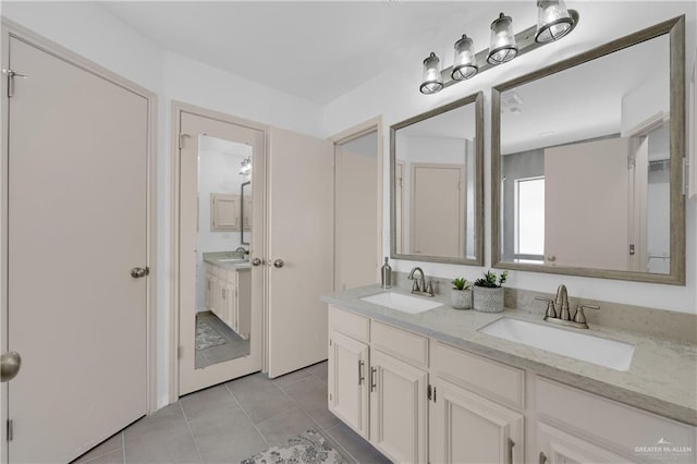 bathroom featuring tile patterned flooring, a sink, and double vanity