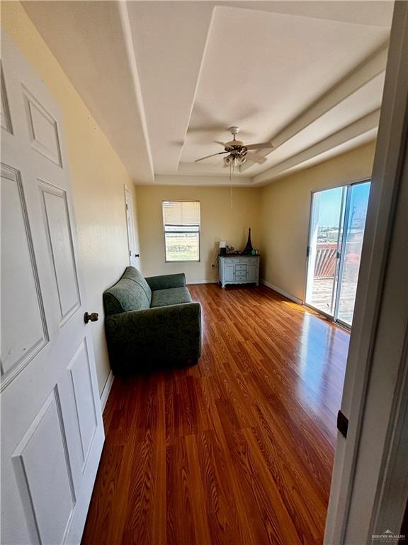 21732 Mile 17 Rd, Edinburg, TX 78541 - living area featuring baseboards, a raised ceiling, a ceiling fan, and wood finished floors