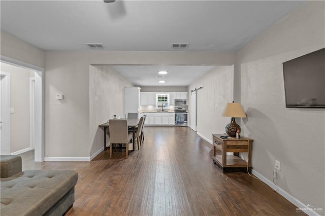 615 Iowa St, Mercedes, TX 78570 - living area with dark wood finished floors, baseboards, and visible vents