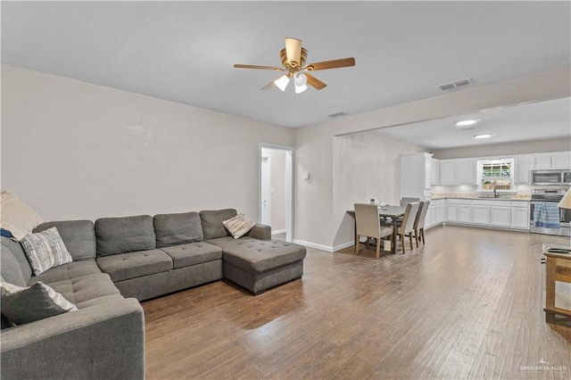 615 Iowa St, Mercedes, TX 78570 - living room with wood finished floors, baseboards, ceiling fan, and visible vents