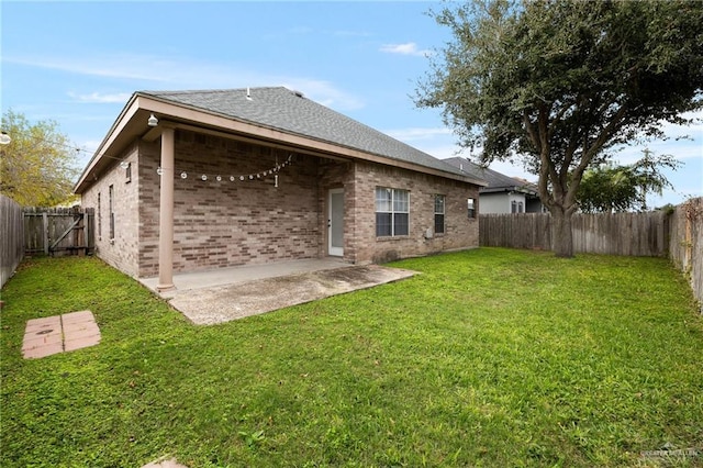 rear view of house featuring a yard and a patio