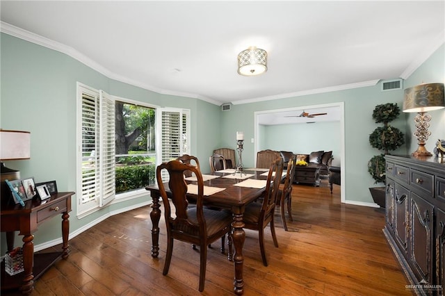 dining room featuring baseboards, visible vents, hardwood / wood-style floors, and ornamental molding