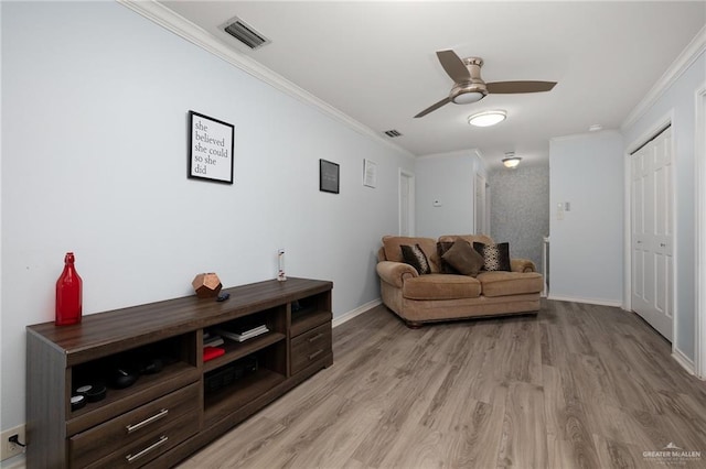 living room featuring visible vents, light wood-style flooring, ornamental molding, ceiling fan, and baseboards