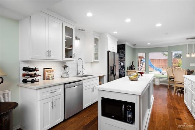 kitchen with stainless steel appliances, tasteful backsplash, dark wood-style flooring, and a sink