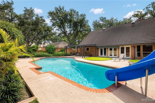 view of pool with french doors, a water slide, a patio area, and a fenced in pool