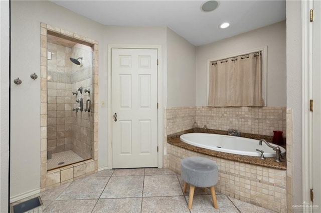 bathroom featuring tile patterned flooring, a garden tub, and a shower stall