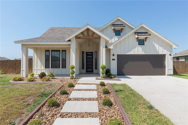 modern inspired farmhouse featuring fence, roof with shingles, board and batten siding, concrete driveway, and an attached garage