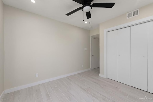 unfurnished bedroom with ceiling fan, a closet, and light hardwood / wood-style flooring