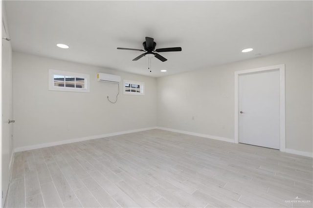 spare room with ceiling fan, light wood-type flooring, and a wall mounted AC