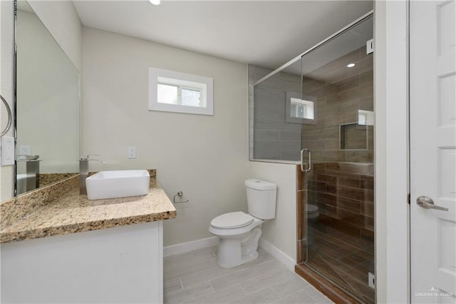 bathroom featuring vanity, toilet, and a shower with shower door