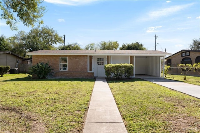 ranch-style home featuring a front yard, a carport, and central air condition unit