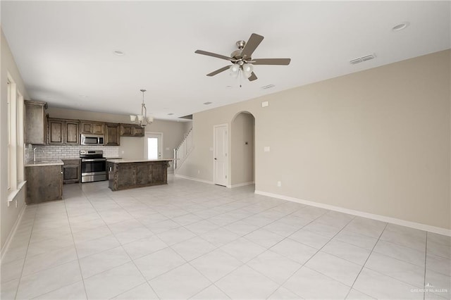 interior space featuring light tile patterned floors, ceiling fan with notable chandelier, and sink