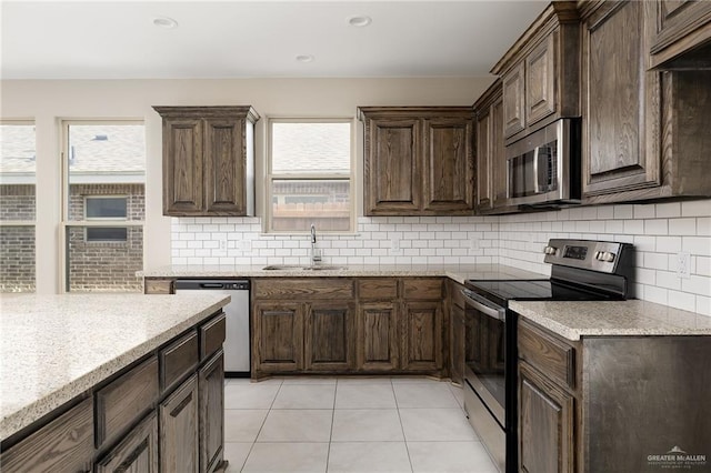 kitchen featuring decorative backsplash, stainless steel appliances, a wealth of natural light, and sink