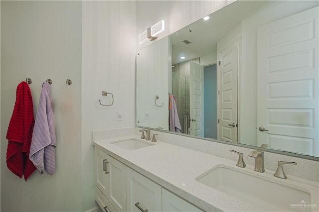 bathroom with a sink, visible vents, a stall shower, and double vanity