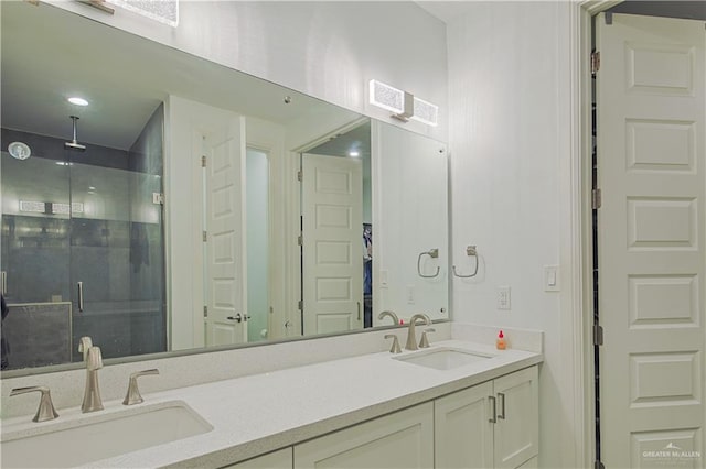 full bath with double vanity, a shower stall, and a sink