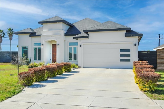 view of front of house featuring a shingled roof, a garage, driveway, and stucco siding